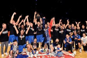 Wellington Saints players and staff celebrating their NBL championship win on court at TSB Arena.