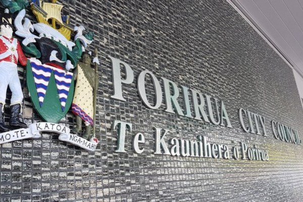 Porirua City Council building wall with crest and bilingual signage.