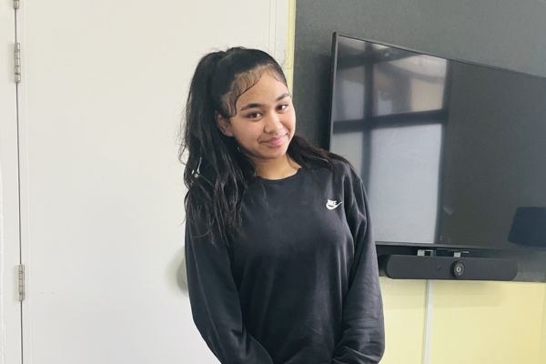 Missing Porirua Teen Emily Teenage girl in black Nike sweatshirt, smiling and standing indoors.