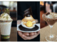 Three indulgent chocolate-themed desserts: a pistachio-topped milkshake with whipped cream, a chocolate tart topped with toasted meringue and a gold chocolate coin, and a chocolate cocktail rimmed with nuts and garnished with whipped cream and chocolate pieces.