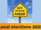 Yellow road sign reading “Rate Increase Ahead” under a blue sky, symbolising rising council rates ahead of the 2025 local elections.