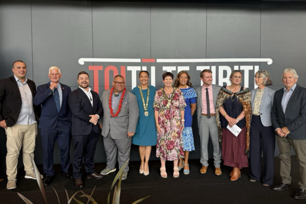 Group photo of Porirua City Council members standing in a row in front of a wall with the words "Toitū Te Tiriti." Mayor Anita Baker is at the centre wearing the mayoral chain, surrounded by councillors dressed in formal attire.