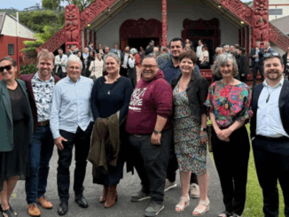 Group photo of Porirua City councillors and Mayor Anita Baker standing in front of a carved wharenui at the Council’s 2025–28 swearing-in ceremony