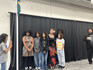 People sing next to a raised Solomon Islands flag at a cultural ceremony in Porirua.