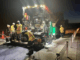 Night-time roadworks underway on Transmission Gully, with workers operating paving machinery under floodlights while traffic lanes are closed.