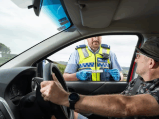 Police officer conducting a roadside saliva drug test during a traffic stop in Porirua.