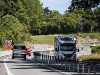 Traffic moves through roadworks on Transmission Gully with cones and temporary barriers in place.