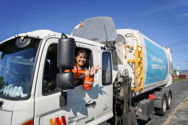 Waste Management driver waves from rubbish truck in Porirua.