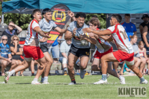 Paremata-Plimmerton player is tackled by multiple Hutt Old Boys Marist defenders during the National Club Sevens at Ngāti Toa Domain.