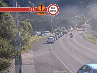 Alt text: Traffic queues on State Highway 58 near Belmont Rd as emergency services respond to a serious crash and road closure.