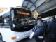 A bus displaying “Train Replacement” picks up commuters at a crowded Wellington station platform.