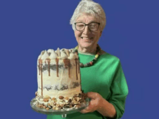 Shirley Gay smiling and holding a decorated cake