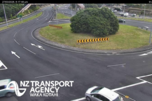 Wide view of a multi-lane roundabout interchange with light traffic and clear road markings.