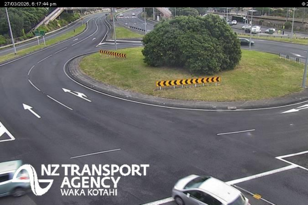 Wide view of a multi-lane roundabout interchange with light traffic and clear road markings.