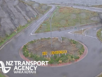 Aerial view of a roundabout connecting multiple streets, with roads branching out in several directions and surrounding urban layout visible.