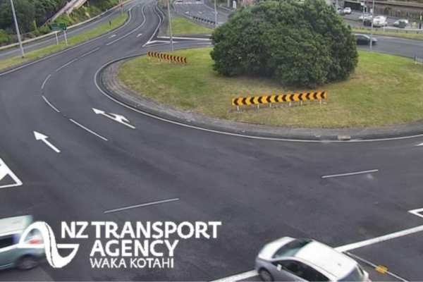 Wide view of a multi-lane roundabout interchange with light traffic and clear road markings.