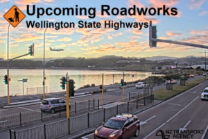 Roadworks warning graphic over a Wellington coastal highway scene, with cars travelling along a multi-lane road beside the harbour at sunset and a plane descending in the background.