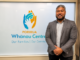 Nu'ulelei Taulalo stands beside Porirua Whānau Centre signage.