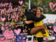 Wellington Phoenix Women players celebrate on the field at Porirua Park after their historic A-League Women semi-final victory on Mother’s Day, surrounded by pink heart and floral artwork overlays.