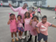 Windley School students and staff wearing pink T-shirts pose together in the playground during Pink Shirt Day celebrations in Porirua.