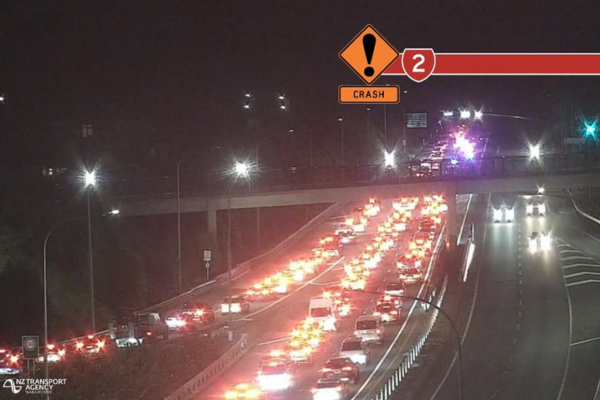 Traffic backed up on State Highway 2 at night after a crash near the Haywards interchange, with emergency lights visible ahead.
