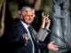 Porirua City Councillor Mike Duncan speaks at an outdoor civic service beside a New Zealand Sign Language interpreter.