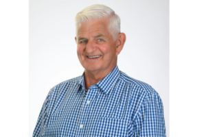 Portrait of Porirua City Councillor Mike Duncan smiling in a blue checked shirt.