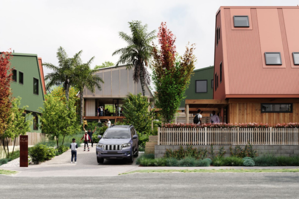 Modern affordable housing development at Our Whare Our Fale in Porirua, featuring colourful multi-storey homes, landscaped shared spaces, mature trees and residents gathered around a central community area.