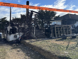 Fire-damaged house in Spur Grove, Tītahi Bay, behind danger tape after a Saturday night blaze.
