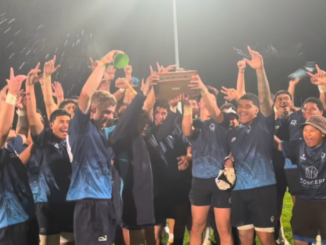 Aotea College 1st XV players celebrate under stadium lights after retaining the Beard Trophy.