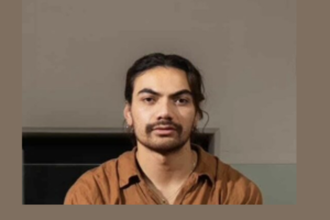 Close-up portrait of Kasi Valu wearing a rust-brown shirt.