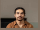 Close-up portrait of Kasi Valu wearing a rust-brown shirt.