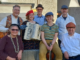 Seven members of the Klezmer Rebs pose together with an accordion, violin and guitar.