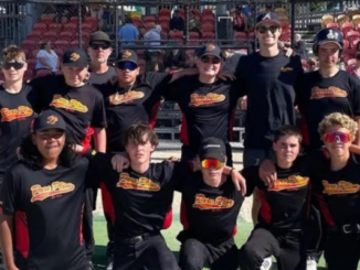 Twelve Paremata Plimmerton Softball Club members pose together in black ParePlim shirts at a softball ground.
