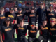 Twelve Paremata Plimmerton Softball Club members pose together in black ParePlim shirts at a softball ground.