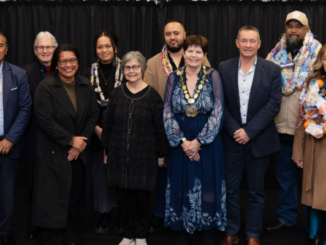 A group of 10 people, some wearing colourful garlands and one wearing a mayoral chain, stand together at the 2026 Porirua Civic Awards.