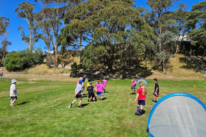 Children play football on a grass field during a Porirua City AFC junior session.