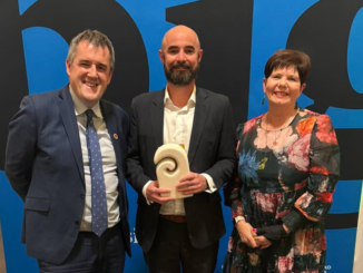 Minister Chris Bishop, Mufftech founder Simon Stone and Porirua Mayor Anita Baker stand together at the Gold Awards, with Stone holding a trophy.