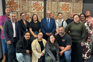 A group of Partners Porirua Trust representatives pose together indoors in front of a patterned wall hanging.