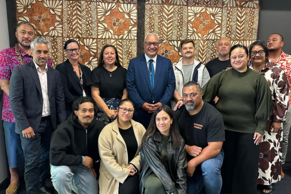 A group of Partners Porirua Trust representatives pose together indoors in front of a patterned wall hanging.