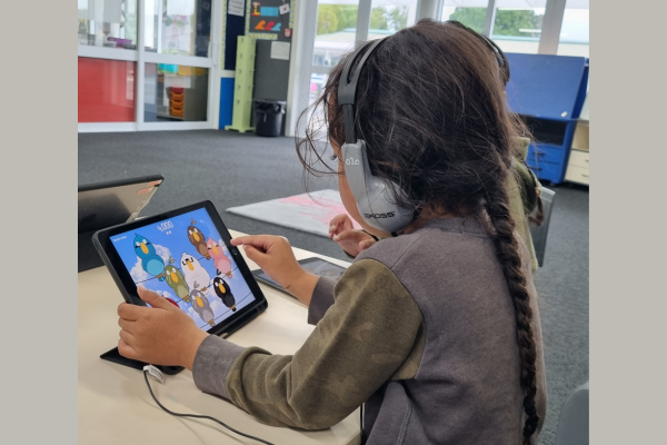 A Porirua primary school student wearing headphones completes a listening activity on a tablet as part of a hearing and auditory processing programme.