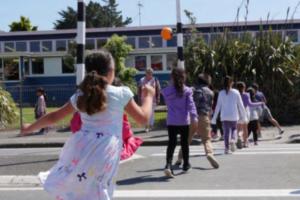 Children use a pedestrian crossing outside a Porirua school as they head towards the school grounds. Porirua City Council is installing new variable 30km/h speed limit signs outside schools to improve safety during school travel times.