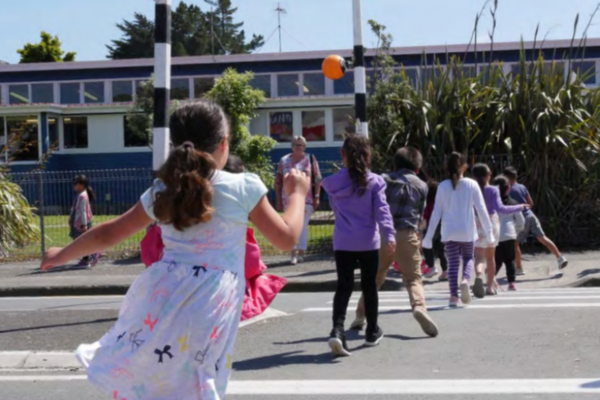 Children use a pedestrian crossing outside a Porirua school as they head towards the school grounds. Porirua City Council is installing new variable 30km/h speed limit signs outside schools to improve safety during school travel times.
