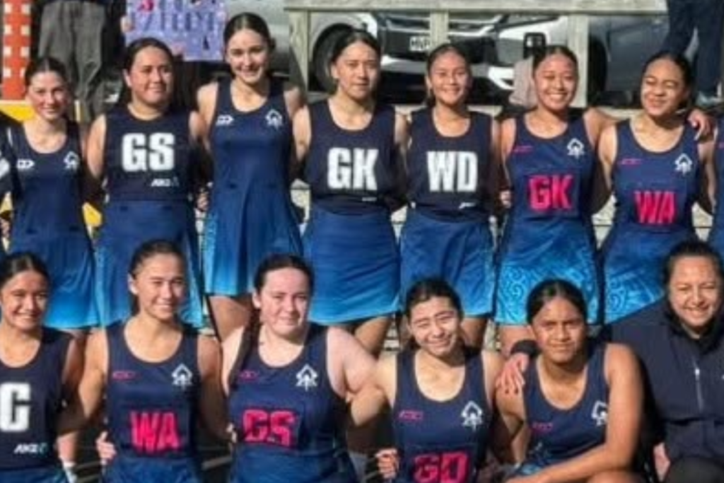 Aotea College netball players in navy uniforms pose together for a team photo.
