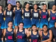 Aotea College netball players in navy uniforms pose together for a team photo.