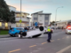 A white car lies upside down on Moorefield Road in Johnsonville as police attend the crash scene.