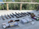 Fifteen firearms, prohibited magazines and boxes of ammunition laid out on a wooden deck after a police search at Crail Bay.