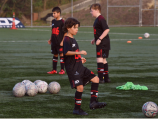 Young Olé Football Academy players training on a football pitch in Porirua.