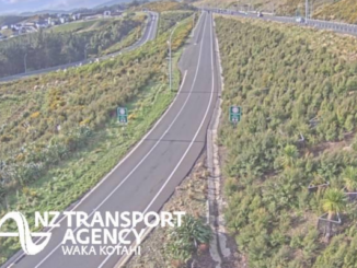 An empty section of divided state highway winding through green hills, with the NZ Transport Agency Waka Kotahi logo in the lower left.