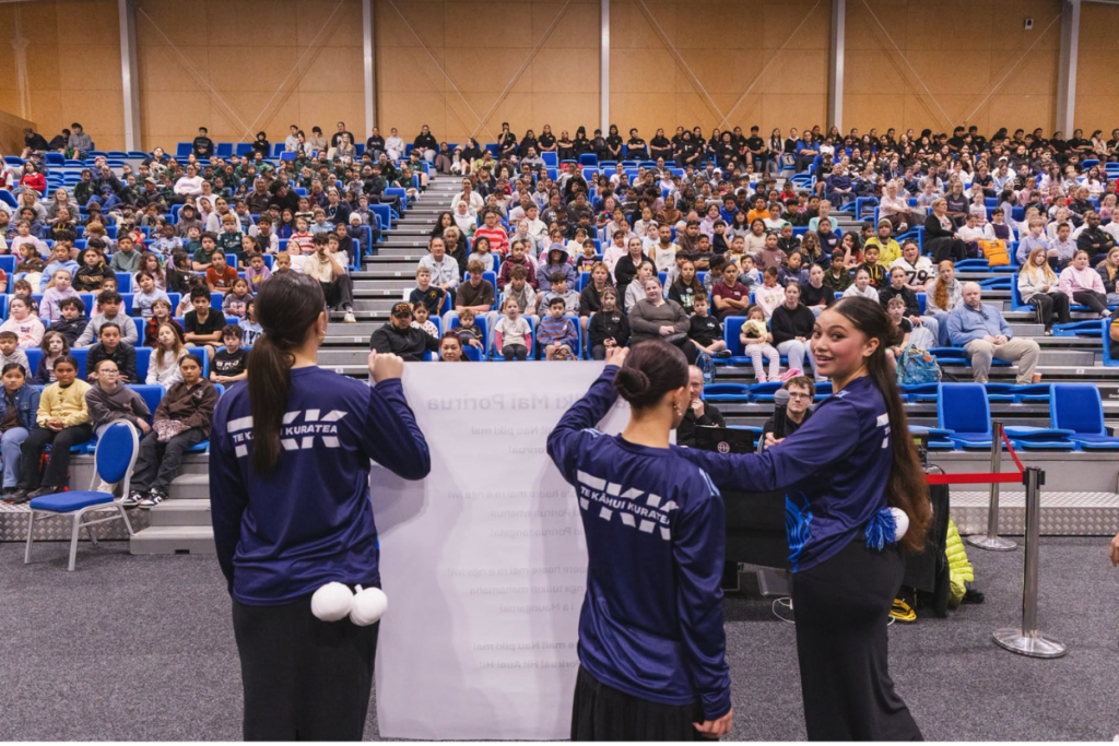Aotea College students lead hundreds of tamariki in waiata at Te Rauparaha Arena during Porirua’s Te Wiki o te Reo Māori celebrations.